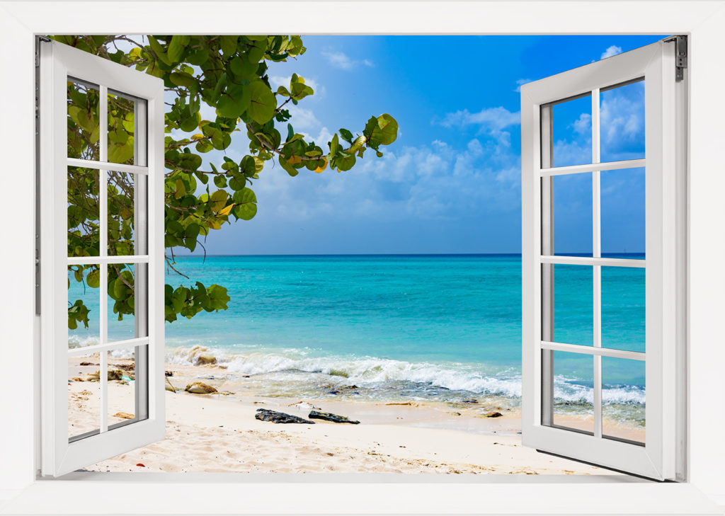 Two white French doors open to a beautiful island beach view